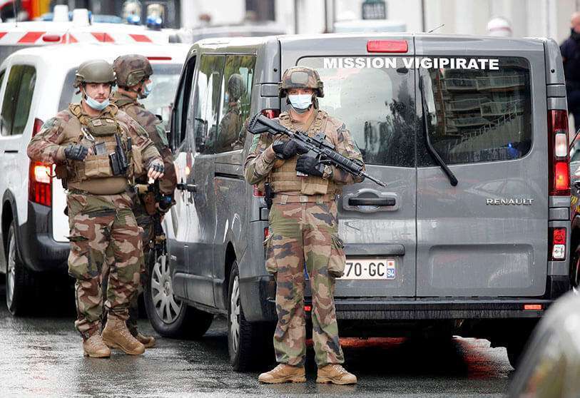 REUTERS/CHARLES PLATIAU - Security forces stand guard at the site of an incident near the former offices of French magazine Charlie Hebdo in Paris, France, on 25 September 2020. 