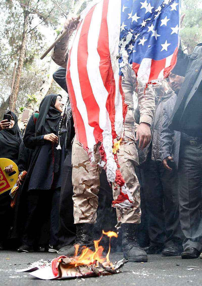 Un manifestante iraní quema la bandera de Estados Unidos mientras asiste a una manifestación contra Estados Unidos, en conmemoración del 40º aniversario de la toma de posesión de la embajada estadounidense, cerca de la antigua embajada estadounidense en Teherán, Irán, el 4 de noviembre de 2019