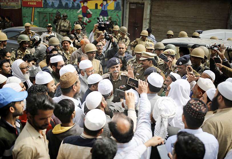 Un alto oficial de policía de Delhi habla con un grupo de musulmanes antes de las oraciones del viernes en Nueva Delhi, India, el viernes 28 de febrero de 2020