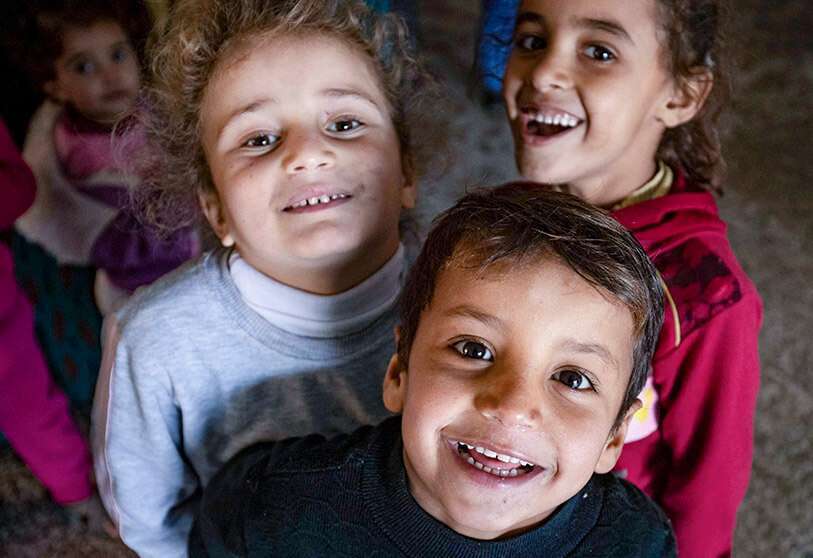 Niños sirios desplazados internamente posan para la cámara en una escuela en un campo en Hasakeh