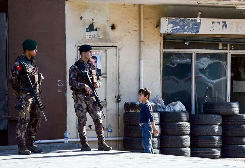 Un niño mira a los oficiales de policía de las fuerzas especiales turcas