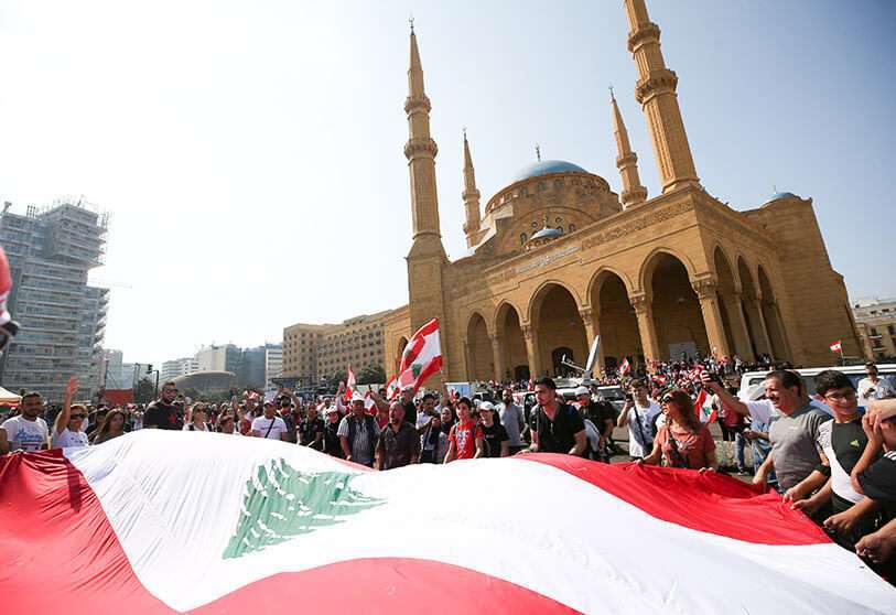 Manifestantes sostienen una bandera libanesa durante una protesta contra el gobierno en el centro de Beirut