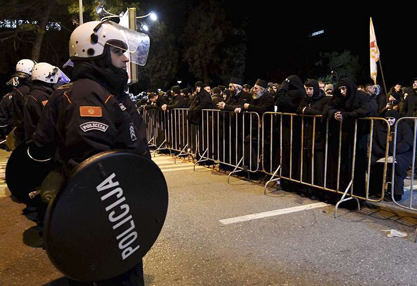 Clérigos y creyentes de la Iglesia Ortodoxa Serbia se paran frente a la Policía cerca del Parlamento