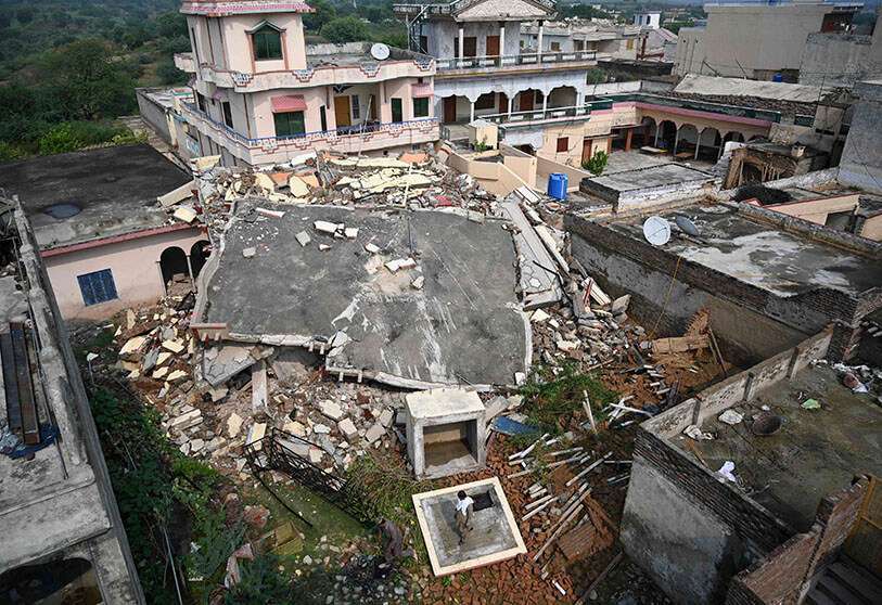 Residentes paquistaníes observan una casa derrumbada en una zona afectada por el terremoto en las afueras de Mirpur, en la Cachemira paquistaní, en septiembre de 2019