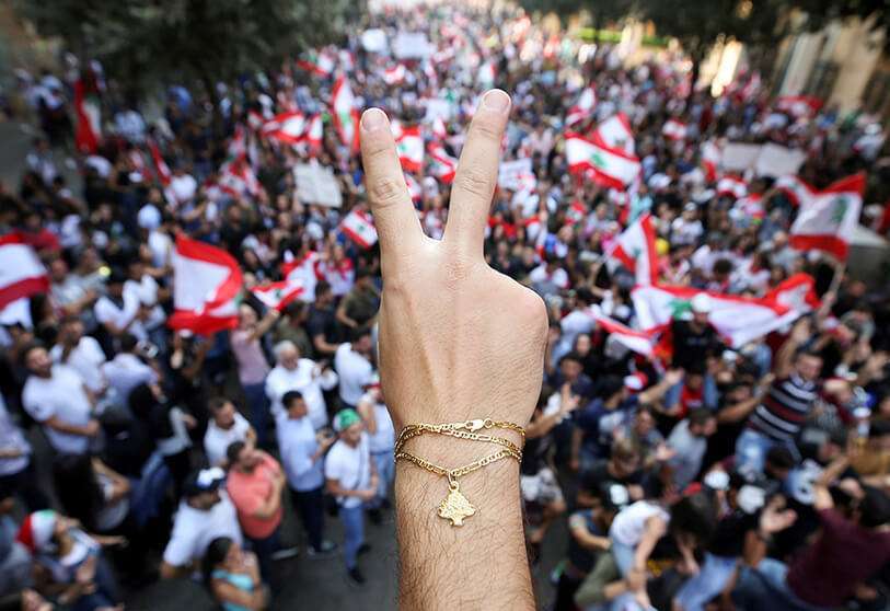 Un manifestante muestra el signo de la victoria durante una protesta contra el gobierno en el centro de Beirut el 21 de octubre de 2019