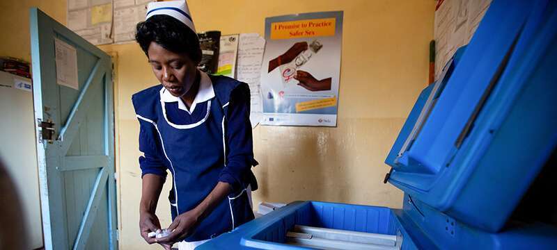 La enfermera Gezile Maseko coloca en un refrigerador las vacunas recién llegadas a un centro de salud en Zambia