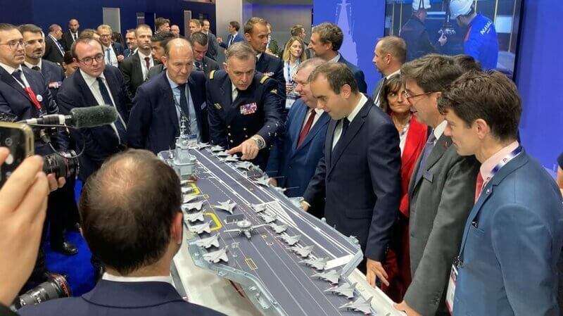 PHOTO/AFP - El nuevo ministro de Defensa francés es Sébastien Lecornu (tercero por la derecha) que, junto a su director de Armamento, Emmanuel Chiva (cuarto), observa una maqueta del que será el segundo portaviones nuclear de la Marina francesa