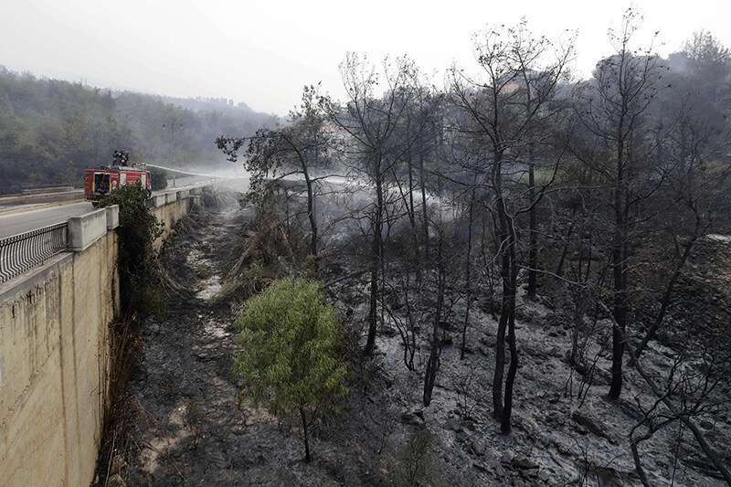 : Los bomberos apagan las llamas después de que se produjeran incendios alrededor de la aldea de Meshref, en las montañas Shouf del Líbano, al sudeste de la capital, Beirut, el 15 de octubre de 2019