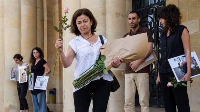 Wadad Halwani, cuyo esposo fue secuestrado y desaparecido en 1982, regala flores a las familias de otras personas desaparecidas durante una manifestación en Beirut / Changiz M Varzi /Al-JAZEERA
