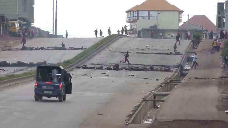 Un vehículo de la policía antidisturbios se acerca a las barricadas instaladas por los manifestantes en una carretera principal del distrito de Sonfonia (Conakry)