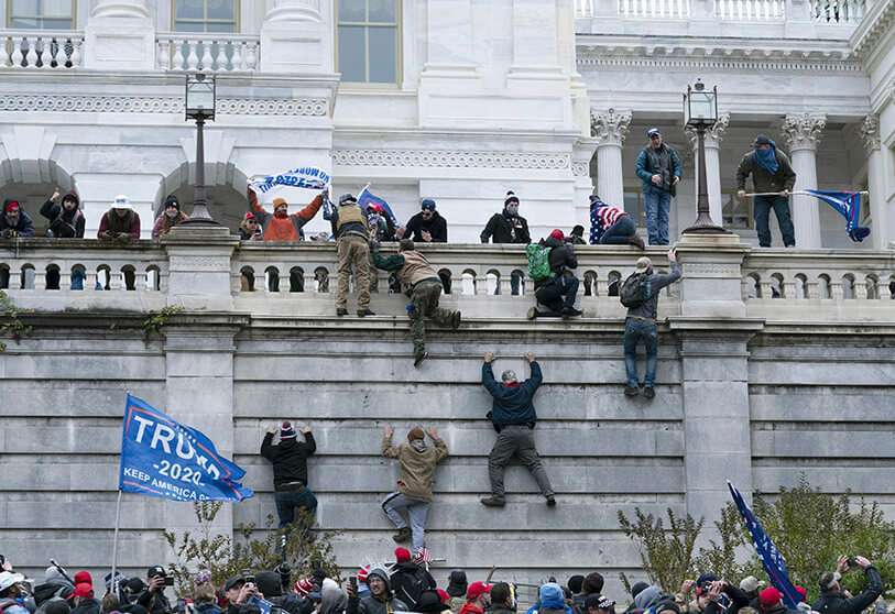 AP/JOSE LUIS MAGANA - Manifestantes pro-Trump escalan un muro mientras asaltan el edificio del Capitolio de Estados Unidos