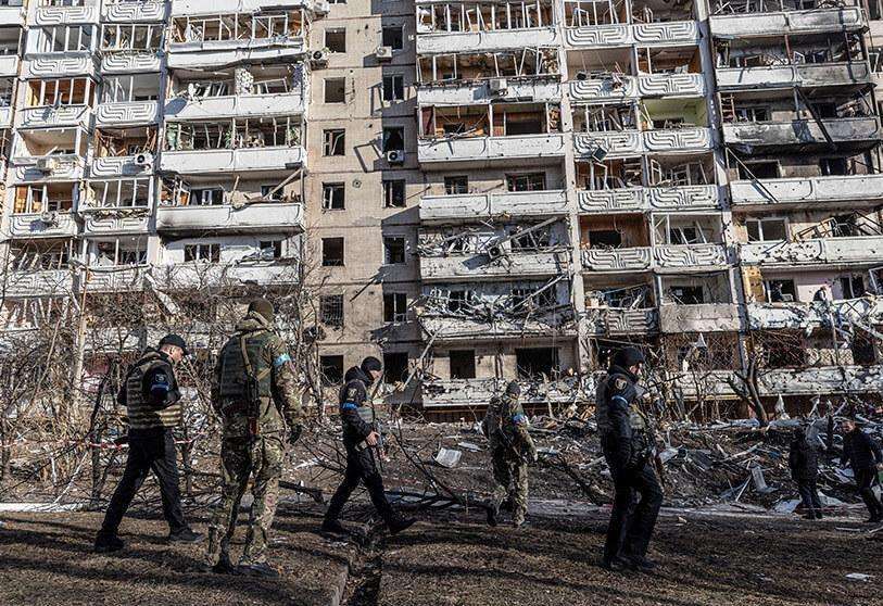 Los militares ucranianos inspeccionan la zona frente a un edificio de apartamentos residenciales después de que fuera alcanzado por los bombardeos mientras continúa la invasión rusa de Ucrania, en Kiev, Ucrania, 15 de marzo de 2022