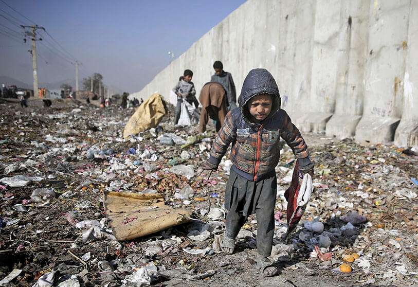 Un niño afgano internamente desplazado busca plástico y otros artículos que pueden ser usados como reemplazo de la leña, en un vertedero de basura en Kabul.