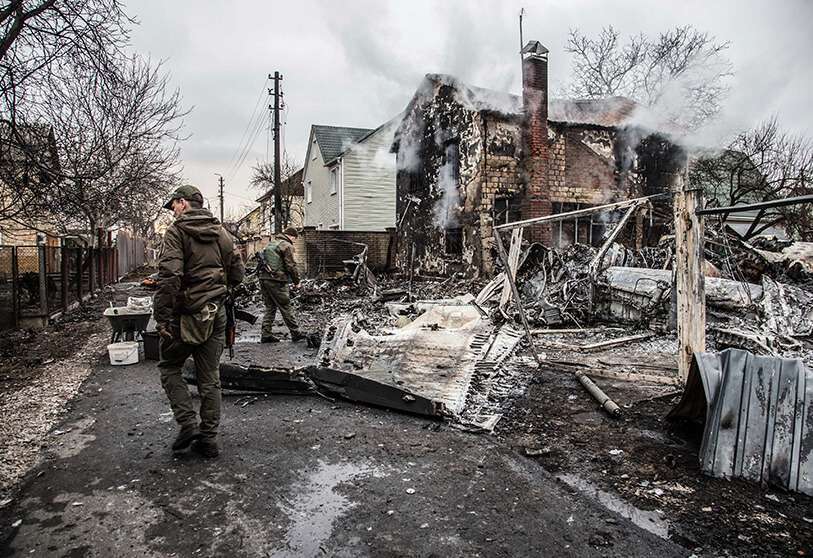 AP/OLEKSANDR RATUSHNIAK - Militares ucranianos caminan junto a los fragmentos de un avión derribado en Kiev, Ucrania, el viernes 25 de febrero de 2022