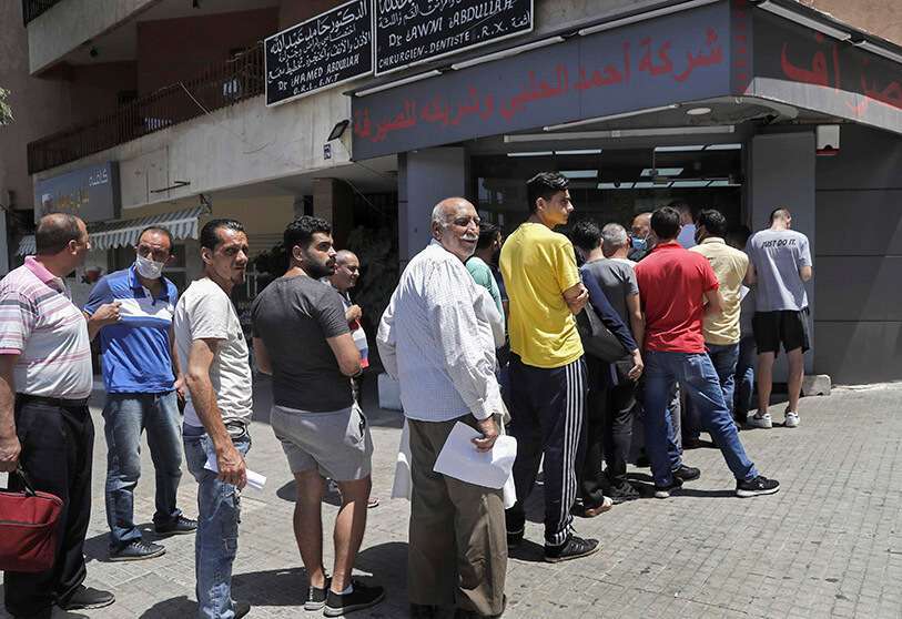La gente hace cola frente a una oficina de cambio para comprar dólares estadounidenses, en Beirut, Líbano AP/HUSSEIN MALLA