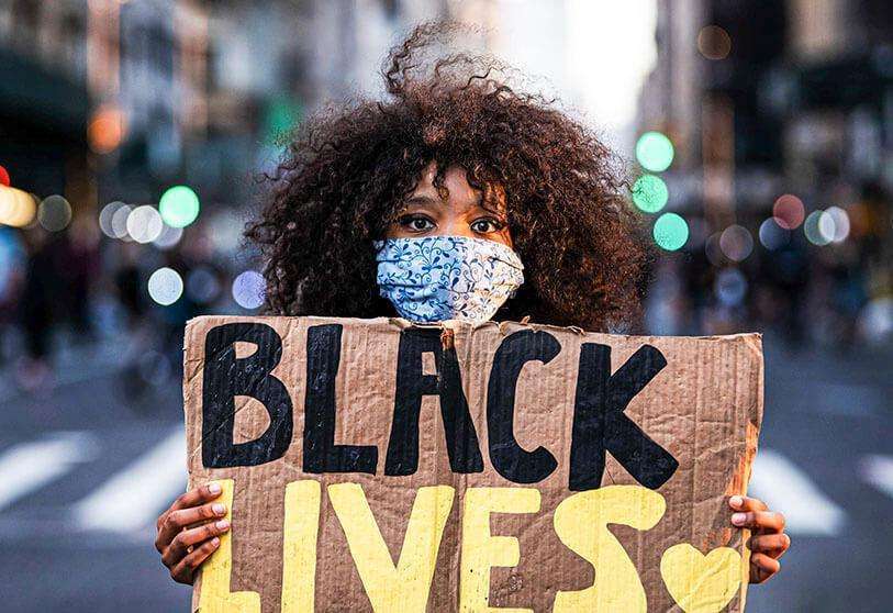 PHOTO/ZUMA  -   Una mujer con un cartel de Black Lives Matter durante una protesta tras la muerte violenta del afroamericano George Floyd por un policía blanco en Minneapolis