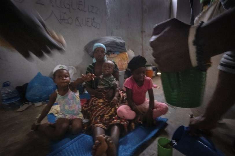 Voluntarios de la parroquia de María Auxiliadora distribuyen raciones de comida entre los supervivientes del ataque a Palma alojados en el pabellón deportivo de Pemba