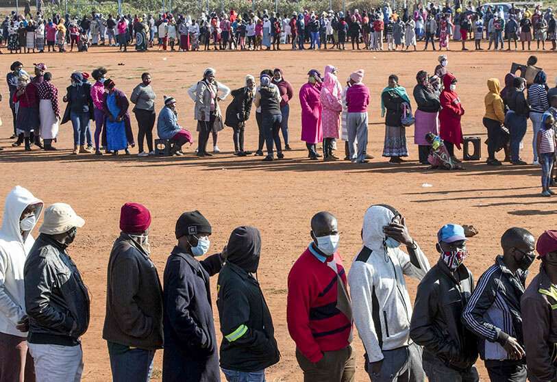  Personas afectadas por la crisis económica del coronavirus hacen cola para recibir donaciones de alimentos en el asentamiento informal de Iterileng, cerca de Laudium, al suroeste de Pretoria (Sudáfrica), el miércoles 20 de mayo de 2020