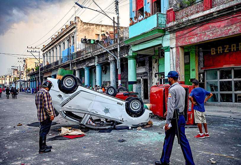 Coches de policía volcados en la calle en el marco de una manifestación contra el presidente cubano Miguel Díaz-Canel en La Habana, el 11 de julio de 2021 AFP/YAMIL LAGE