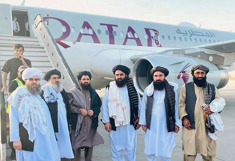 Des délégués talibans devant un avion de Qatar Airways dans un lieu non identifié en Afghanistan, sur cette photo publiée sur les médias sociaux le 8 octobre 2021