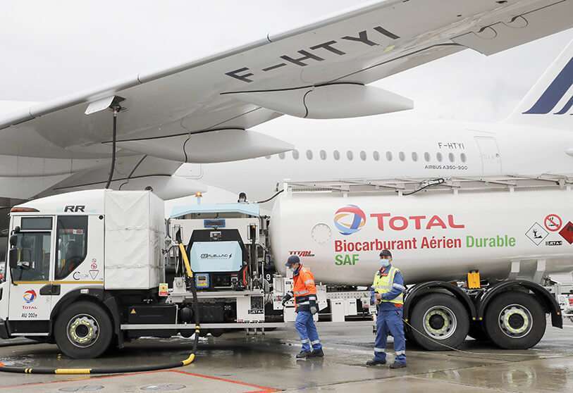 Trabajadores repostan un Airbus A350 con combustible de aviación sostenible en el aeropuerto de Roissy, al norte de París, el martes 18 de mayo de 202