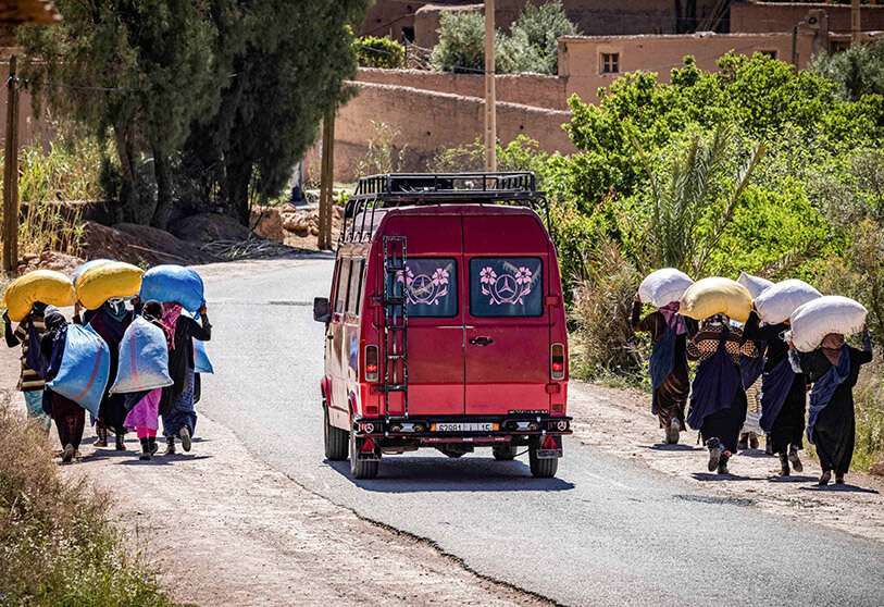 Des ouvriers portent des sacs de roses récoltées dans un champ près de la ville de Kelaat Mgouna (ou Tighremt NImgunen), dans la province de Tinghir, au centre du Maroc, dans les montagnes de l'Atlas.