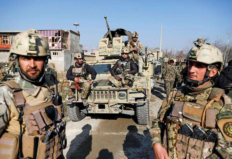 Las fuerzas de seguridad afganas cerca del lugar de un ataque en una base aérea militar estadounidense en Bagram, al norte de Kabul, Afganistán