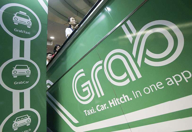 Anuncio del servicio de reservas de transporte GRAB en una estación de tren de Singapur