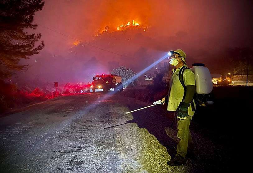 Los bomberos, ayudados por voluntarios locales, luchan por extinguir un incendio forestal en Oren, en la región turística de Mugla, el 6 de agosto de 2021, mientras Turquía lucha contra los incendios forestales más mortíferos de las últimas décadas