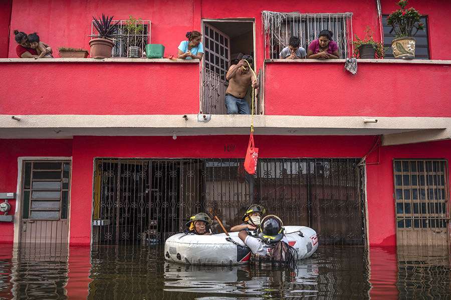 Los servicios de emergencia salvan a las personas con botes de goma en una calle inundada después de que las fuertes lluvias azotaran el estado de Tabasco