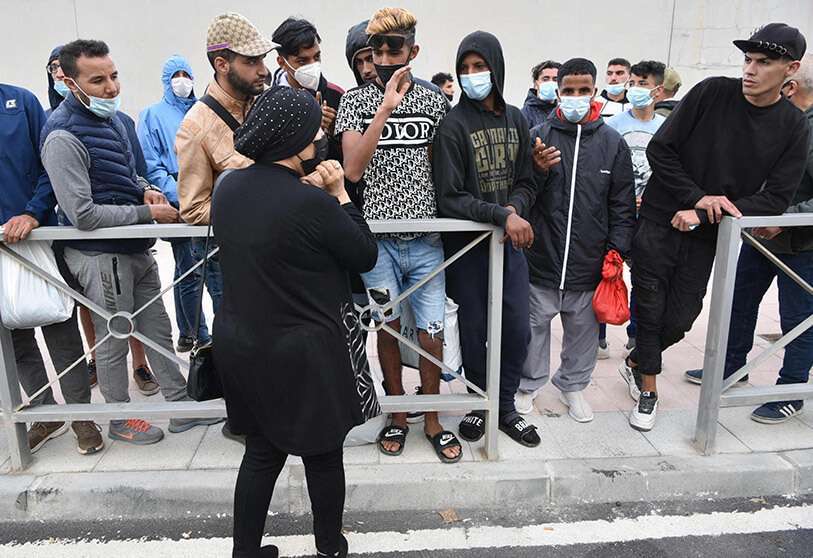 Inmigrantes esperan para cruzar la frontera con Marruecos en el enclave español de Ceuta el 20 de mayo de 2021