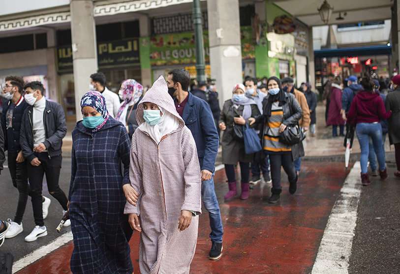 Personas con mascarillas para protegerse de la propagación del coronavirus, en una calle concurrida, en Rabat PHOTO/AP