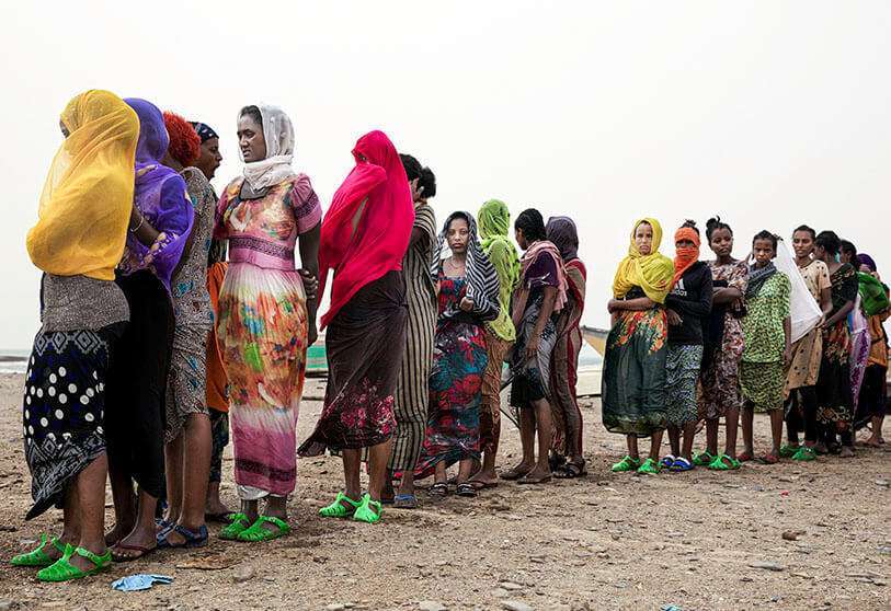 PHOTO/AP - Migrantes etíopes hacen cola mientras son contados por los contrabandistas tras llegar a la aldea costera de Ras al-Ara desde Djibouti, en Lahj (Yemen)