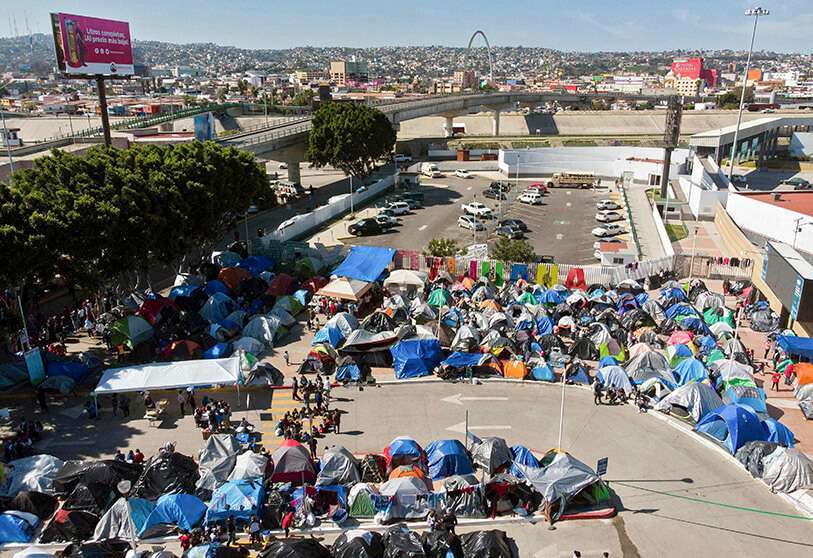 AFP/GUILLERMO ARIAS-Vista aérea de un campamento de migrantes en el que esperan que las autoridades estadounidenses les permitan iniciar su proceso migratorio a las afueras del puerto de cruce El Chaparral, en Tijuana, estado de Baja California, México, el 17 de marzo de 2021