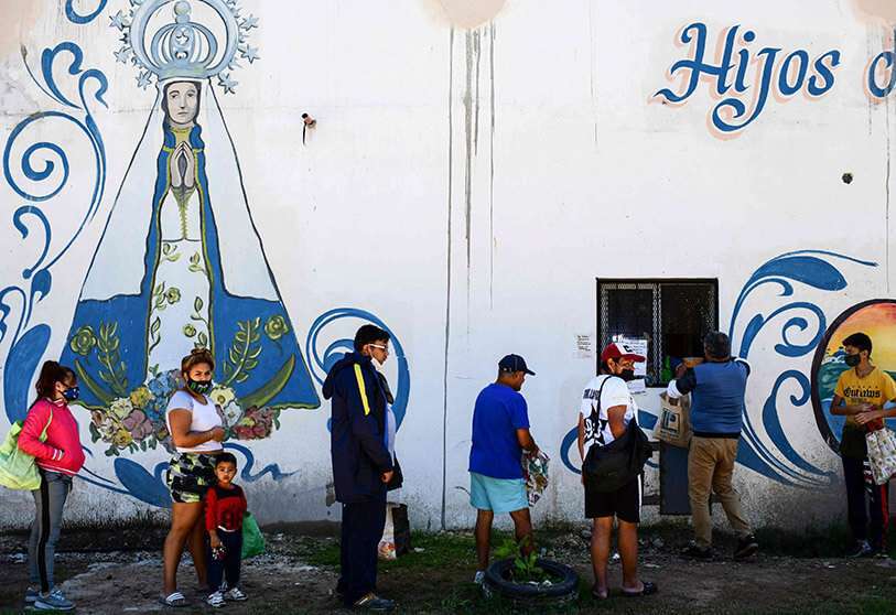 Las personas hacen fila para recibir alimentos en un comedor comunitario en el barrio Puerta de Hierro, en el municipio de La Matanza, provincia de Buenos Aires, Argentina PHOTO/AFP