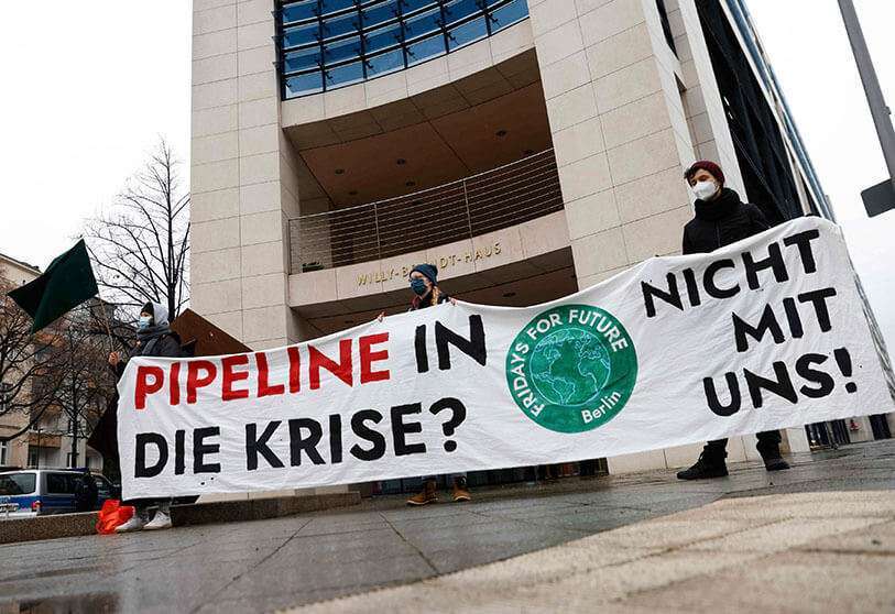 Activistas del movimiento de protección medioambiental y climática "Viernes por el Futuro" sostienen una pancarta en la que se lee "¿Gasoducto hacia la crisis? No con nosotros" mientras se manifiestan contra el gasoducto NordStream 2 y las infraestructuras relacionadas con el gas el 12 de enero de 2021 frente a la sede del partido socialdemócrata SPD en Berlín AFP/ODD ANDERSEN