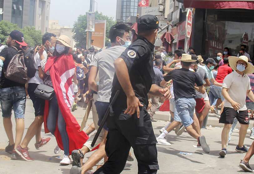 Un agente de Policía tunecino se enfrenta a los manifestantes durante una manifestación en Túnez, Túnez, el domingo 25 de julio de 2021