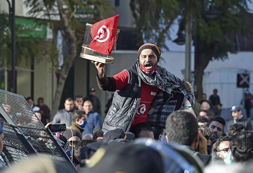 AFP/ FETHI BELAID -Un manifestante tunecino levanta una jaula con la bandera durante una manifestación antigubernamental en la avenida Habib Bourguiba en la capital, Túnez, el 19 de enero de 2021
