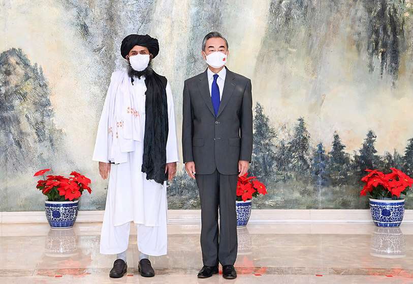 el cofundador de los talibanes, el mulá Abdul Ghani Baradar, a la izquierda, y el ministro de Asuntos Exteriores chino, Wang Yi, posan para una foto durante su reunión en Tianjin, China