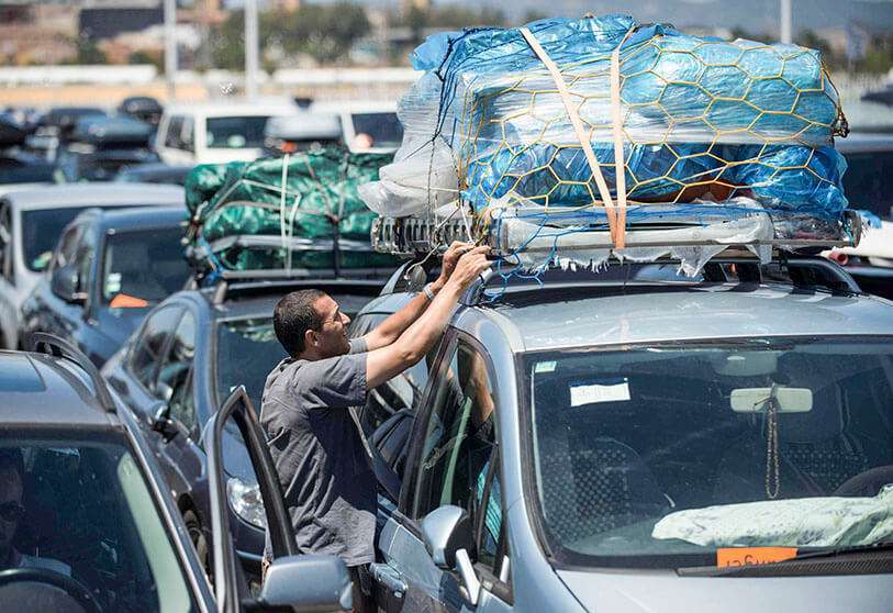 AFP/JORGE GUERRERO - Un hombre revisa su equipaje mientras espera para embarcar en los transbordadores con destino a Tánger en el puerto de Algeciras el 27 de julio de 2019