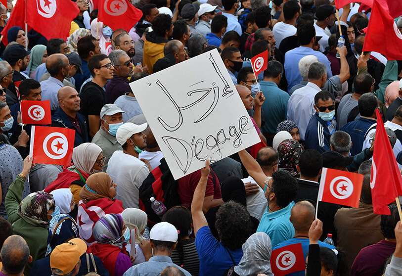 AFP/ FETHI BELAID - Des Tunisiens brandissent des drapeaux nationaux lors d'une manifestation contre leur président le long de l'avenue Habib Bourguiba, dans la capitale Tunis, le 10 octobre 2021.