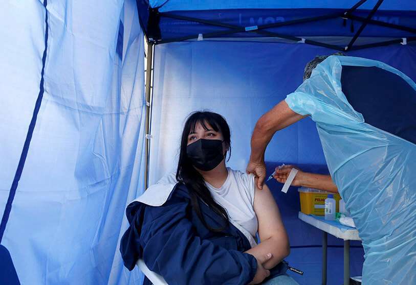 Una mujer recibe una dosis de la vacuna de Pfizer/BioNTech contra la enfermedad del coronavirus (COVID-19) en un estadio deportivo durante la pandemia, en Viña del Mar, Chile